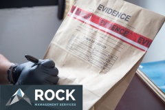hand in glove writing on evidence bag and seal by red tape in crime scene