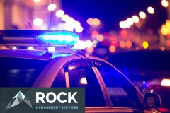 Blue light flasher atop of a police car. City lights on the background.