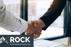 Entrepreneurs collaboration deal shaking hands in a modern office and financial paper graph on desk.