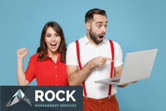 Shocked young couple two friends man woman in white red clothes pointing index finger on laptop pc computer doing winner gesture isolated on blue color background. St. Valentine's Day holiday concept.