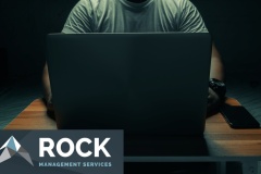 A man in a white shirt sits on a laptop in a dark room. with light shining down. internet concept addiction.topview.